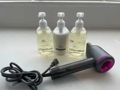 a hairdryer with two bottles and a hair brush at GalleryInn Fuji, Shibuya in Tokyo
