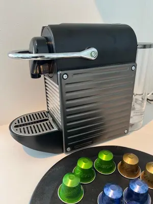 a coffee maker with green cups on a table at GalleryInn Fuji, Shibuya in Tokyo