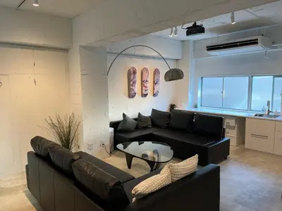 a living room with a black couch and a table at GalleryInn Fuji, Shibuya in Tokyo