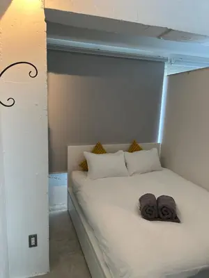 a white bed with two towels on top of it at GalleryInn Fuji, Shibuya in Tokyo