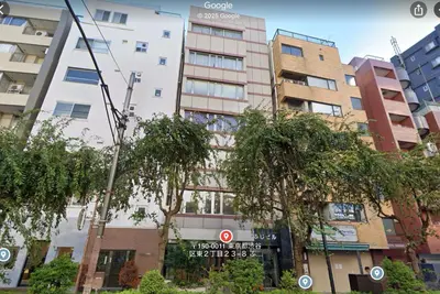 a tall white building with trees in front of it at GalleryInn Fuji, Shibuya in Tokyo
