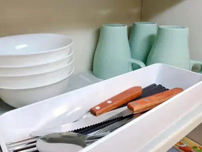 a white drawer with utensils and plates and bowls at nestay suite tokyo tabata in Tokyo