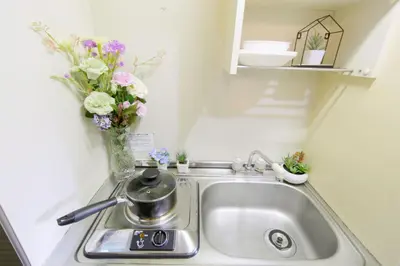 a kitchen sink with a vase of flowers on it at nestay suite tokyo tabata in Tokyo