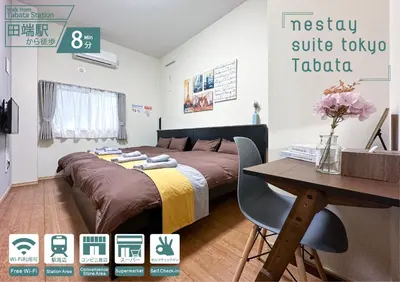 a bedroom with a bed and a table and a sign at nestay suite tokyo tabata 03 in Tokyo