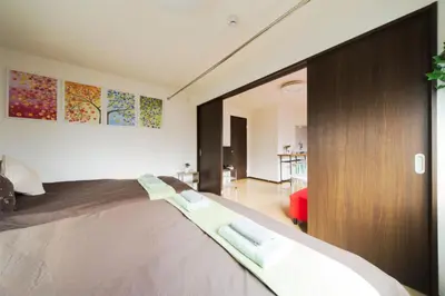 a bedroom with a large bed and a living room at nestay suite tokyo tabata 03 in Tokyo
