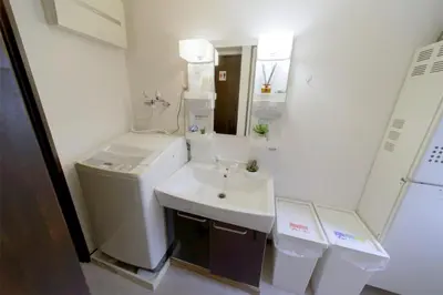 a white bathroom with a sink and a mirror at nestay suite tokyo tabata 03 in Tokyo