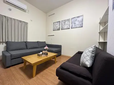 a living room with two couches and a coffee table at nestay suite tokyo tabata 03 in Tokyo