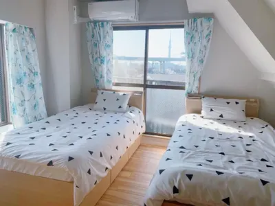 a bedroom with two beds and a window at \u6d45\u8349\u57084\u5c42\u72ec\u680b\u522b\u5885 \u514d\u8d39\u505c\u8f66\u573a \u8fd1\u8f66\u7ad9 \u53ef\u76f4\u8fbe\u673a\u573a in Tokyo