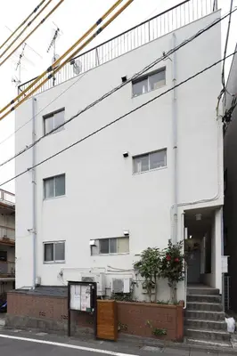 a white building with stairs and plants in front of it at G&R House 101 in Tokyo
