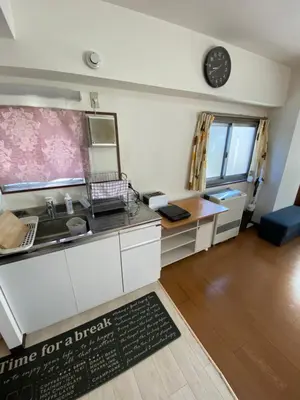 a kitchen with a sink and a clock on the wall at G&R House 101 in Tokyo