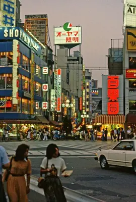 two women walking down a busy city street at night at G&R House 101 in Tokyo