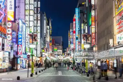 a busy city street at night with people walking around at G&R House 101 in Tokyo