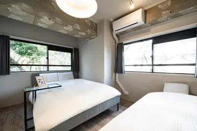 a bedroom with two beds and two windows at Eims stay Oomori206 in Tokyo
