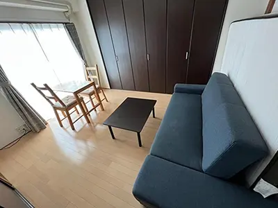 a living room with a blue couch and a table at G&R House 201 in Tokyo