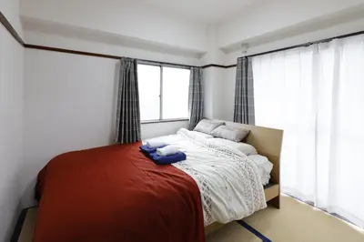 a bedroom with a bed with a red blanket at G&R House 201 in Tokyo