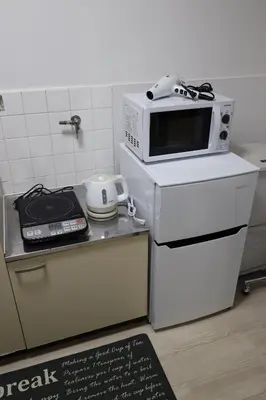 a microwave sitting on top of a stove in a kitchen at G&R House 201 in Tokyo