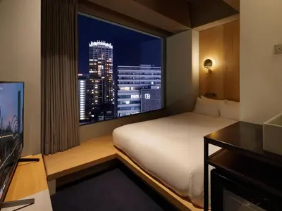 a hotel room with a bed and a large window at sequence MIYASHITA PARK - Shibuya in Tokyo