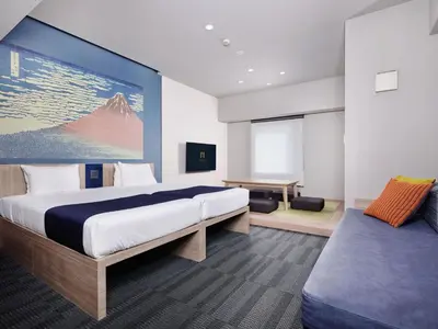 a hotel room with a large bed and a desk at MONday Apart Ueno Shinokachimachi in Tokyo