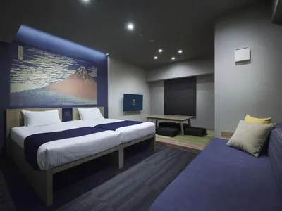 a bedroom with a large bed and a desk at MONday Apart Ueno Shinokachimachi in Tokyo