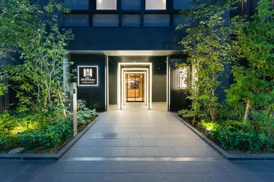 a hallway leading to a building with a door at MONday Apart Ueno Shinokachimachi in Tokyo