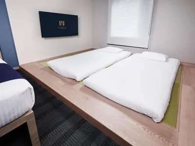 two beds sitting on a wooden table in a room at MONday Apart Ueno Shinokachimachi in Tokyo