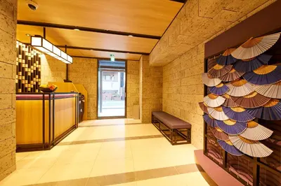 a lobby with a waiting room with a bench at MONday Apart Premium HAMAMATSUCHO in Tokyo