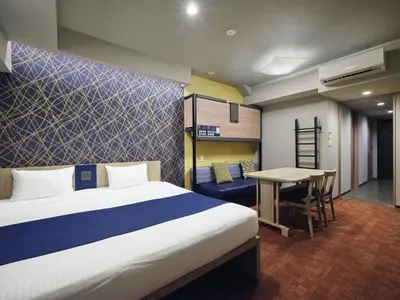 a hotel room with a bed and a desk and a bunk bed at MONday Apart Premium Nihonbashi in Tokyo