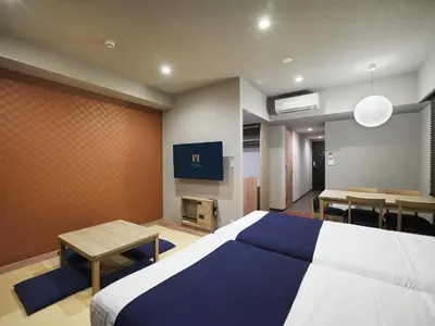a bedroom with a bed and a table and a tv at MONday Apart Premium Nihonbashi in Tokyo