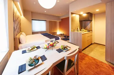 a hotel room with a bed and a table with food on it at MONday Apart Premium Nihonbashi in Tokyo