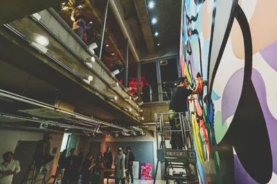 a group of people standing in a room with skis at BnA WALL in Tokyo
