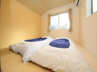 two beds in a room with a window at COTO Tokyo Shibuya 8 in Tokyo
