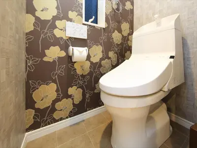 a bathroom with a toilet with a flower wallpaper at COTO Tokyo Shibuya 8 in Tokyo