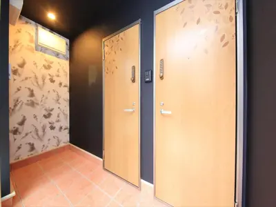 two wooden doors in a room with blue walls at COTO Tokyo Shibuya 8 in Tokyo