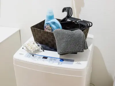a basket on top of a toilet with a bottle of soap at COTO Tokyo Shibuya 8 in Tokyo