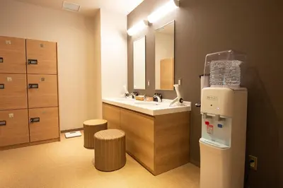 a bathroom with a sink and a mirror and a refrigerator at Wires Hotel Shinagawa Seaside in Tokyo