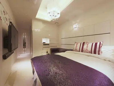 a bedroom with a large bed and a chandelier at HOTEL GLANZ CASCATA in Tokyo