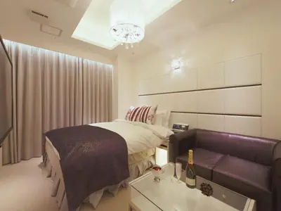 a bedroom with a bed and a couch at HOTEL GLANZ CASCATA in Tokyo