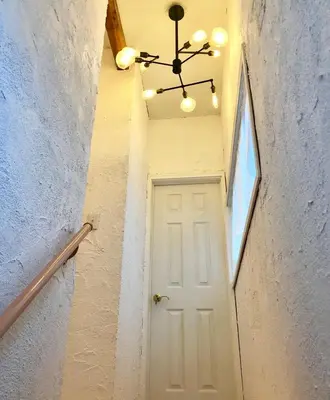 a hallway with a white door and a chandelier at \u30db\u30c6\u30eb The Standard Apartment SHIBUYA SASAZUKA B\u30eb\u30fc\u30e0 in Tokyo