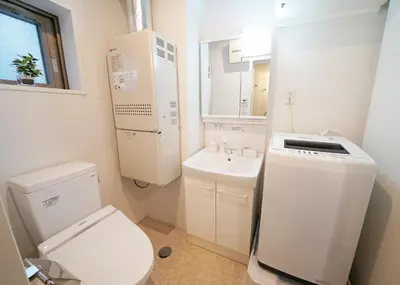 a white bathroom with a toilet and a sink at Laffitte Hirai Condominium Hotel in Tokyo