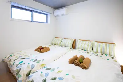 two stuffed animals on a bed in a bedroom at Laffitte Hirai Condominium Hotel in Tokyo