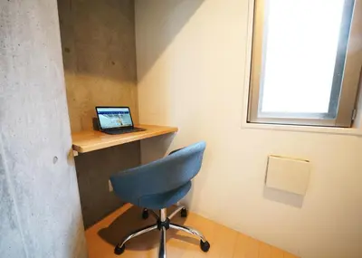 a room with a desk with a laptop and a chair at Laffitte Hirai Condominium Hotel in Tokyo
