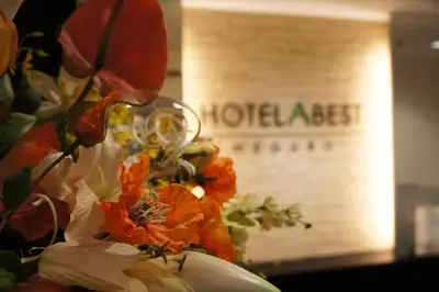 a vase with flowers in front of a hotel act sign at Hotel Abest Meguro / Vacation STAY 71400 in Tokyo