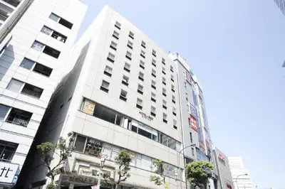 a tall white building with trees in front of it at Hotel Abest Meguro / Vacation STAY 71402 in Tokyo
