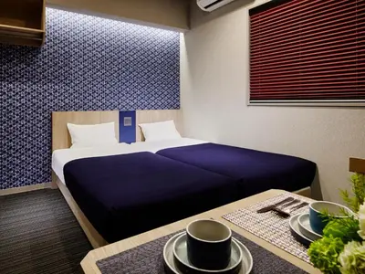 a bedroom with a bed and a table with plates on it at Minn Nishi Kasai in Tokyo