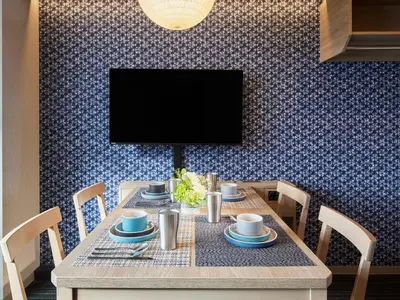a dining room with a table with chairs and a tv at Minn Nishi Kasai in Tokyo