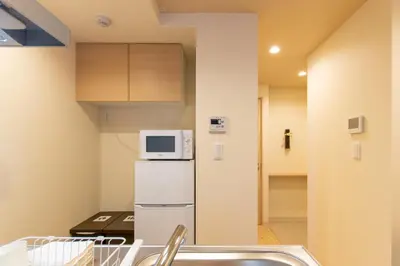 a small kitchen with a refrigerator and a microwave at VACATION INN HEIWAJIMA I in Tokyo