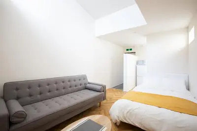 a bedroom with a bed and a couch at \u30b9\u30dd\u30eb\u30c8\u6771\u4eac in Tokyo