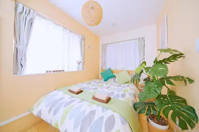 a bedroom with a bed and a potted plant at nestay villa tokyo otsuka in Tokyo
