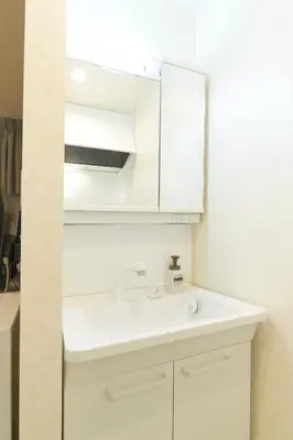 a bathroom with a white sink and a mirror at Ruma Inn Ikebukuro in Tokyo
