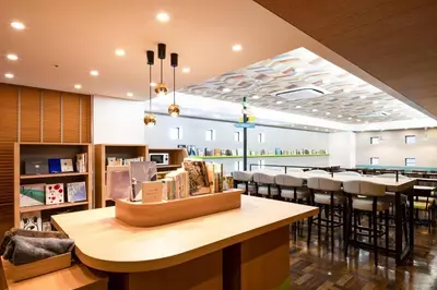 a restaurant with a bar with stools and a dining room at Comfort Hotel Tokyo Higashi Nihombashi in Tokyo